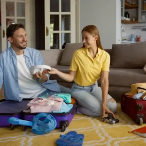 Coppia prepara le valigie per un viaggio, discutendo cosa portare