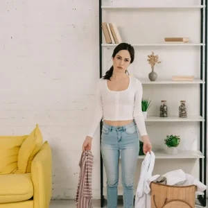 Donna che fa decluttering per vendere casa, concetto home staging fai-da-te.