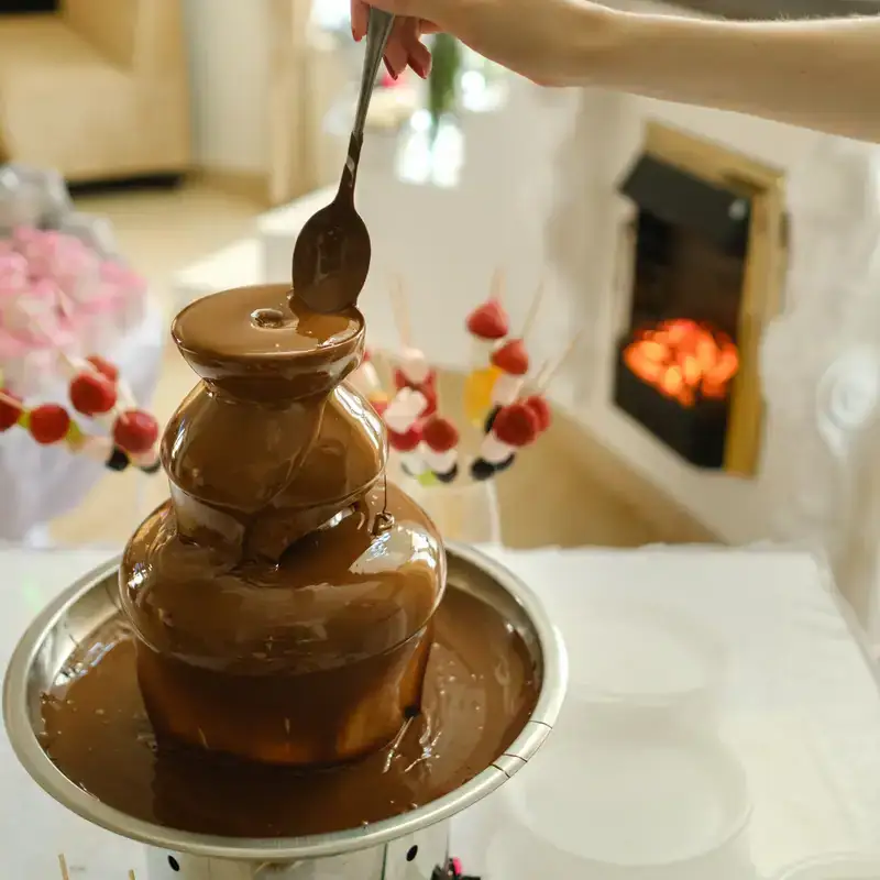 Fontana di cioccolato e decorazioni dolci in ambiente domestico