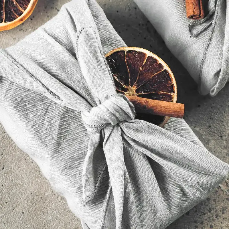 Furoshiki giapponese in lino grigio, annodato attorno a un pacchetto