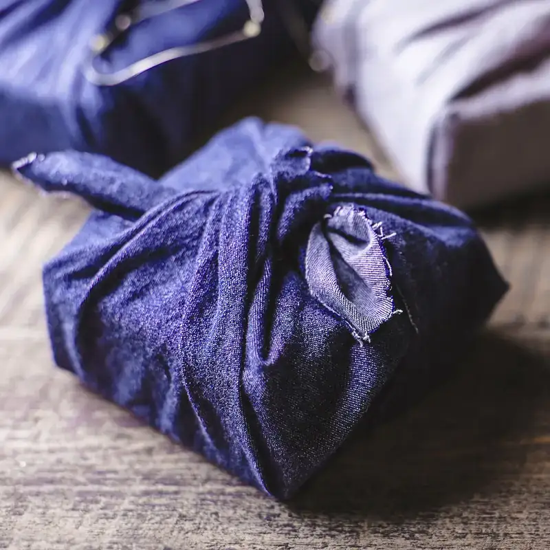 Pacchetto avvolto in un furoshiki di tessuto blu
